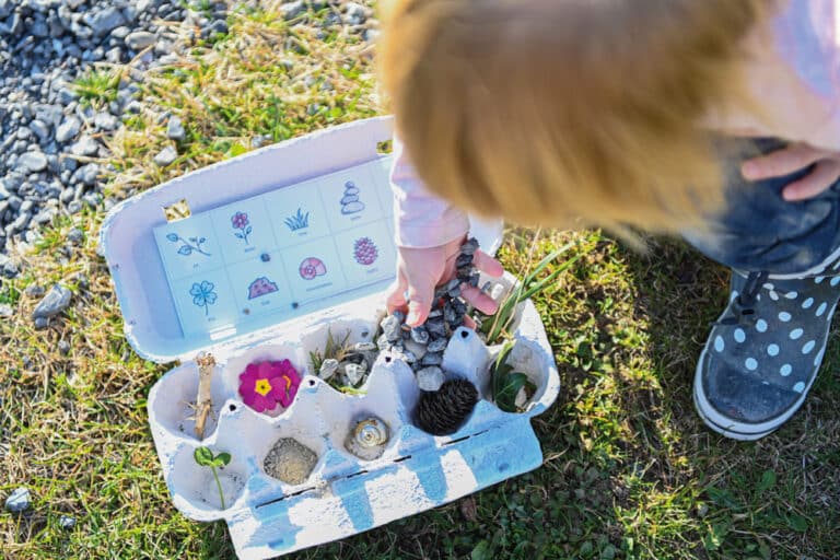 Kinder in ihrer Natur: Kind spielt mit Naturbingo aus Eierkarton und Naturmaterialien